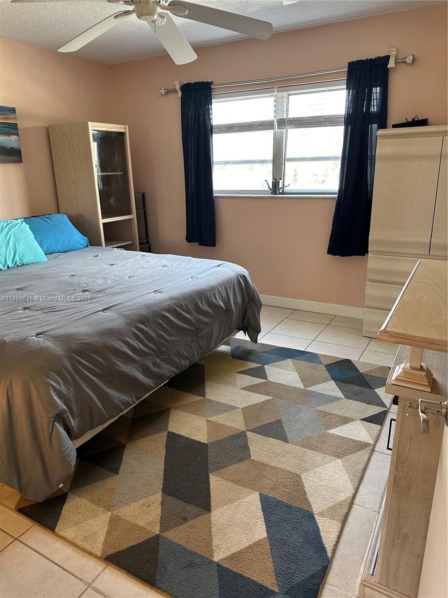 581 Blue Heron Drive, Unit 208B Hallandale Beach, FL 33009 - Photo 15 of 23 a bedroom with a bed and wooden floor