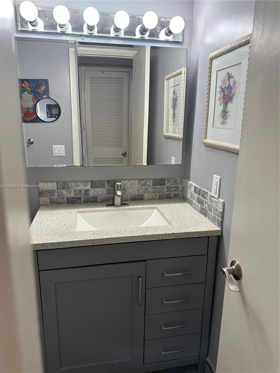581 Blue Heron Drive, Unit 208B Hallandale Beach, FL 33009 - Photo 16 of 23 a bathroom with a sink and a mirror