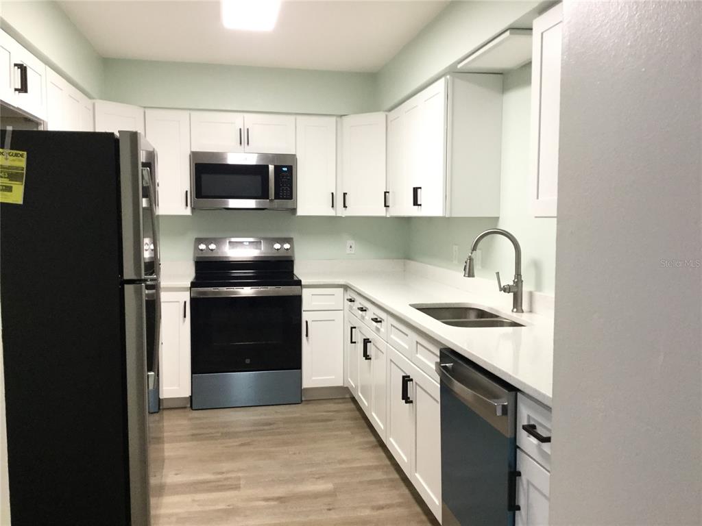 1744 Southwest 108th Lane, Unit B Ocala, FL 34476 - Photo 2 of 15 a kitchen with stainless steel appliances a refrigerator stove and sink