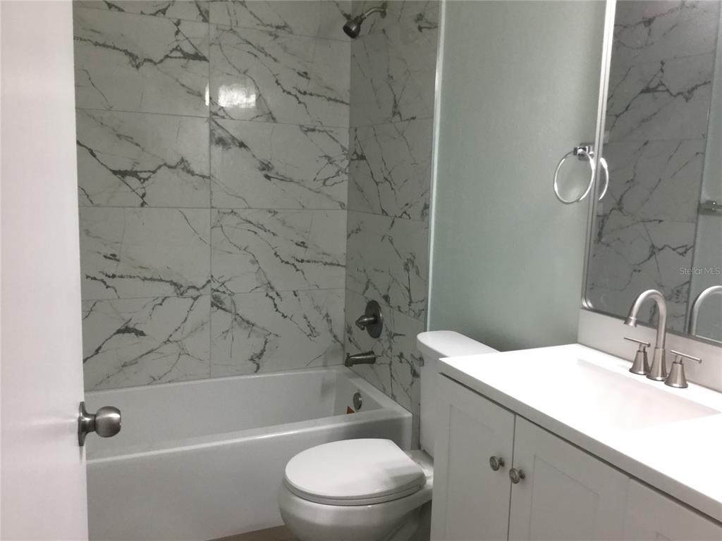 1744 Southwest 108th Lane, Unit B Ocala, FL 34476 - Photo 7 of 15 a bathroom with a granite countertop bathtub shower sink vanity and toilet