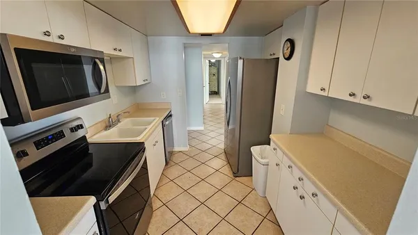 a kitchen with stainless steel appliances a stove microwave and refrigerator