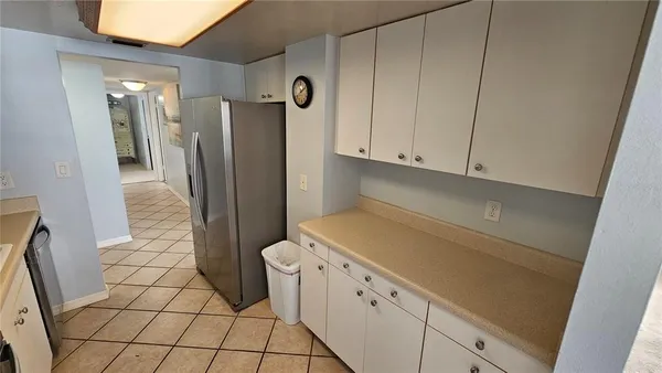 a kitchen with cabinets and a refrigerator