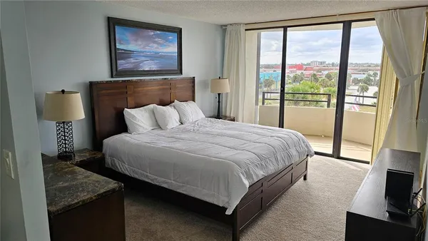 a bedroom with a bed and a flat tv screen on a dresser