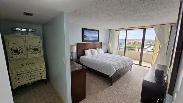 a bedroom with a bed and a view of living room