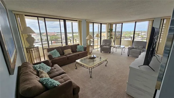 a living room with furniture and floor to ceiling windows