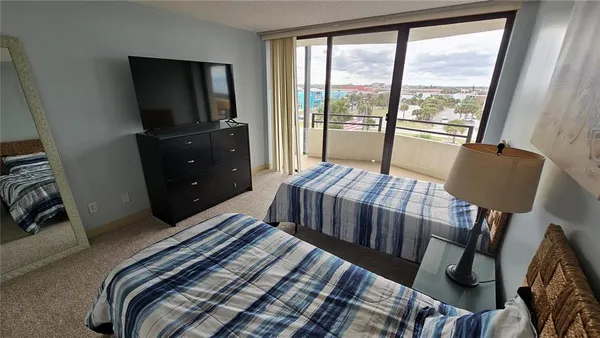 a bedroom with a bed and a flat tv screen on a dresser