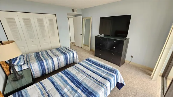 a bedroom with two beds and a flat screen tv