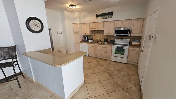 a kitchen with granite countertop a sink a stove top oven and refrigerator