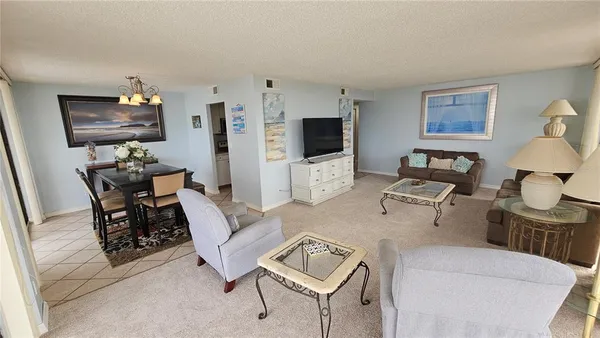 a living room with furniture a flat screen tv and a window