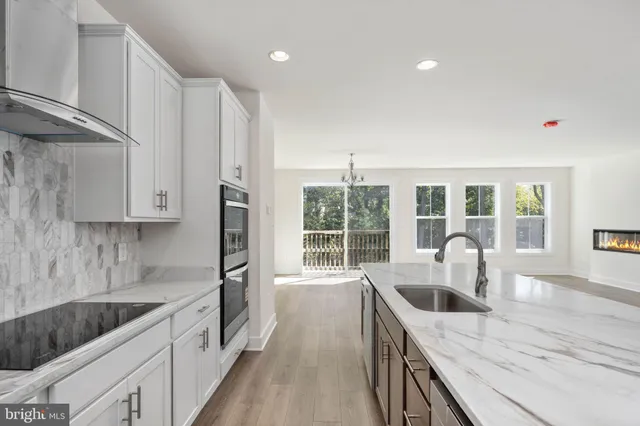 a kitchen with granite countertop a sink stove and refrigerator