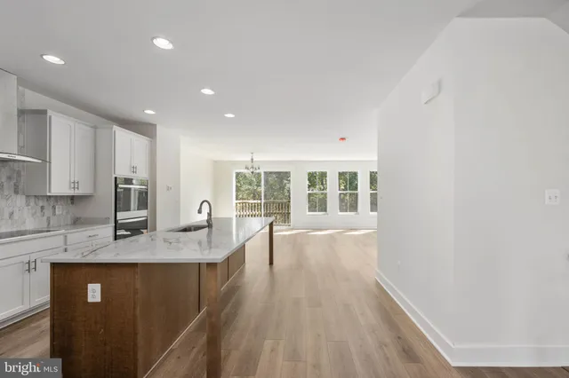 a view of a hallway with wooden floor and entryway