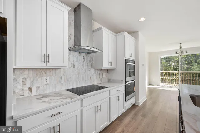 a view of kitchen with wooden floor and electronic appliances