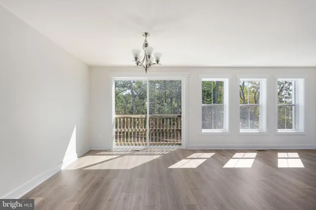 a large kitchen with kitchen island a sink wooden floor and a refrigerator