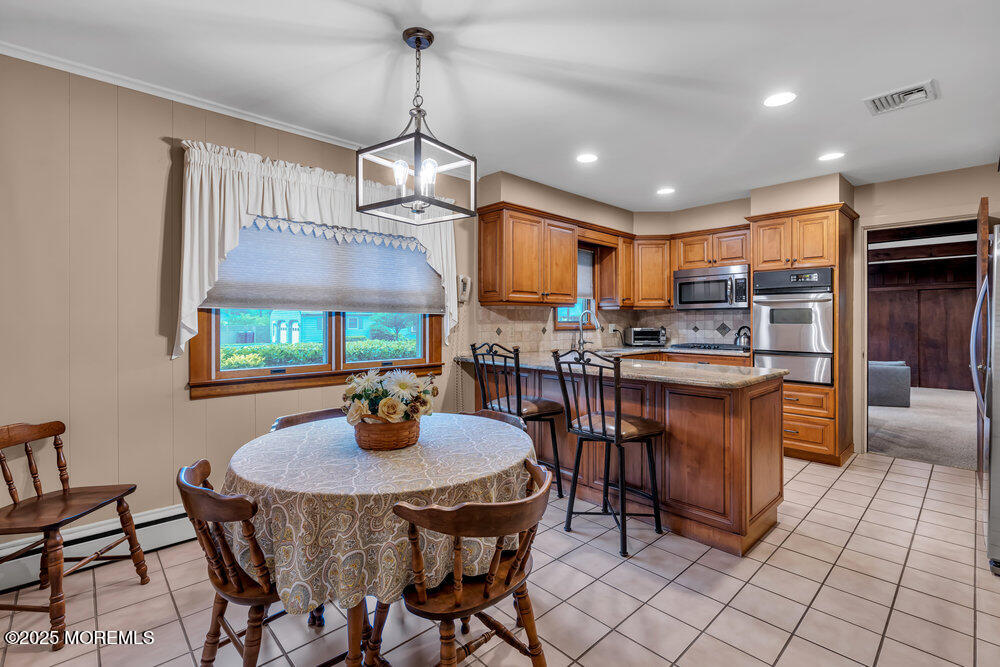 2308 Logan Road Asbury Park, NJ 07712 - Photo 11 of 37 a kitchen with stainless steel appliances granite countertop a sink a stove a dining table and chairs