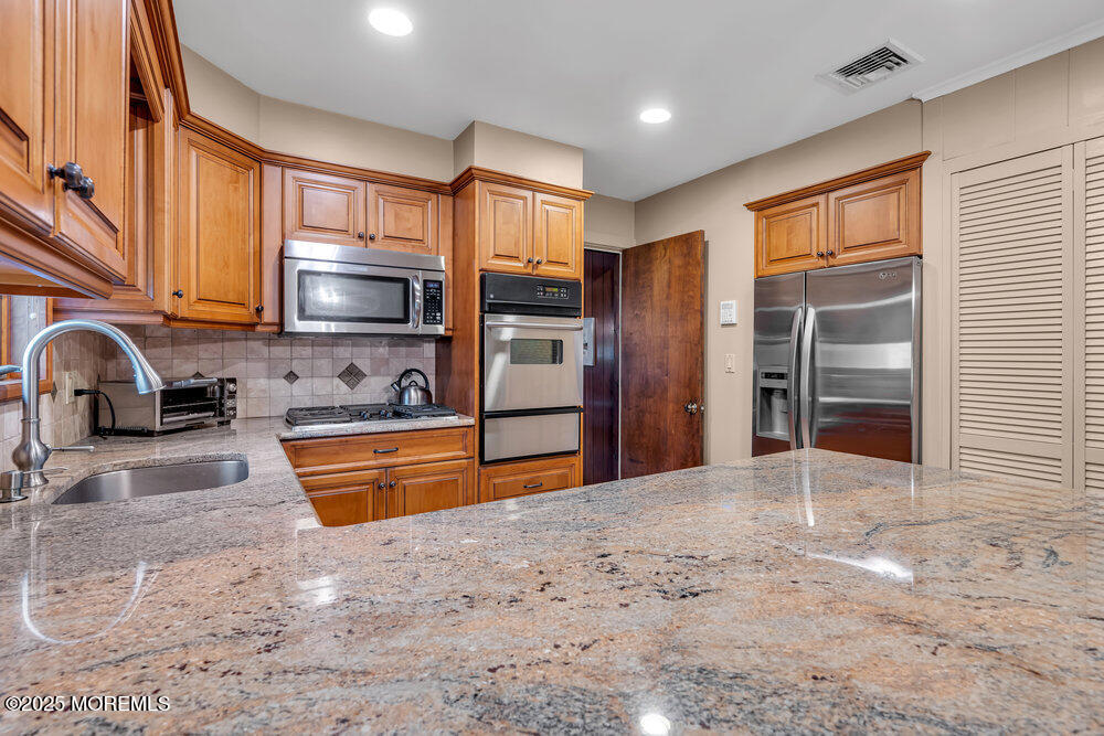 2308 Logan Road Asbury Park, NJ 07712 - Photo 13 of 37 a kitchen with stainless steel appliances granite countertop a refrigerator and a sink
