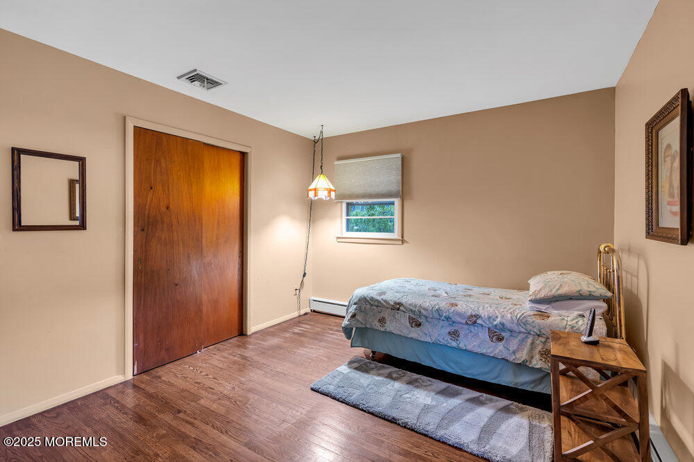 2308 Logan Road Asbury Park, NJ 07712 - Photo 23 of 37 a bedroom with a bed and wooden floor