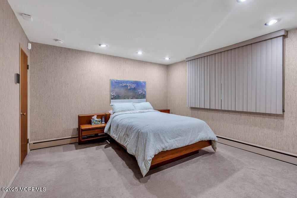 2308 Logan Road Asbury Park, NJ 07712 - Photo 27 of 37 a bedroom with a bed and a refrigerator