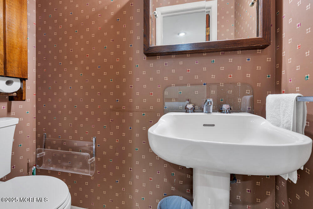 2308 Logan Road Asbury Park, NJ 07712 - Photo 30 of 37 a bathroom with a toilet a sink and mirror