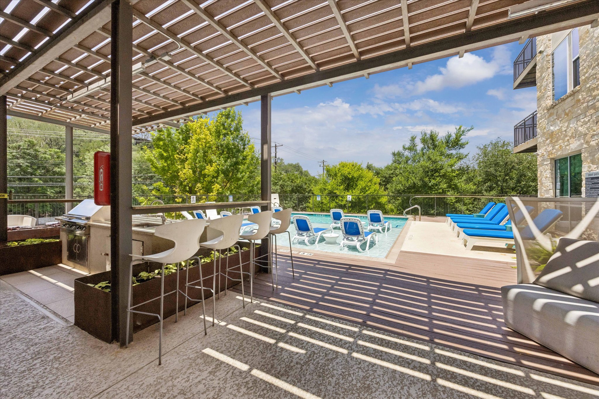1900 Barton Springs Road, Unit 4041 Austin, TX 78704 - Photo 27 of 35 A spacious outdoor lounge area with a built-in barbecue and a refreshing pool, perfect for entertaining.