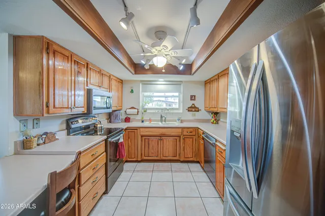 a large kitchen with stainless steel appliances granite countertop a refrigerator a sink dishwasher a stove and white cabinets