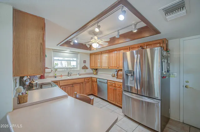 a kitchen with stainless steel appliances granite countertop a refrigerator and a sink