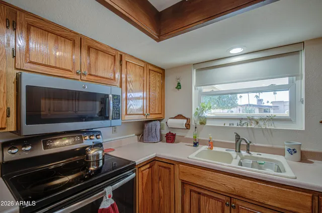 a kitchen with wooden cabinets a sink and a stove top oven