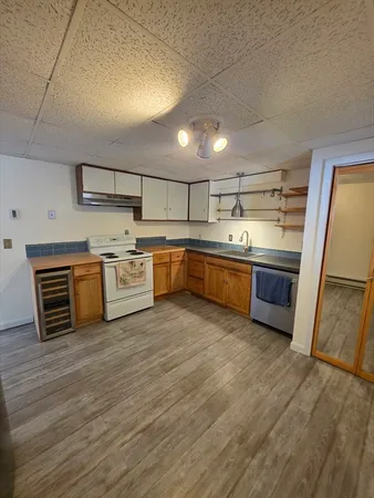 a large kitchen with wooden floors and stainless steel appliances