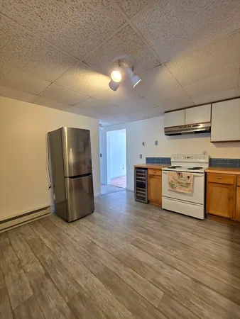 a view of a kitchen with stainless steel appliances wooden floor and large windows