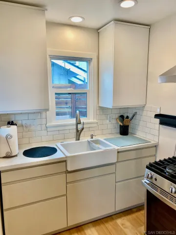 a kitchen with sink a stove and cabinets