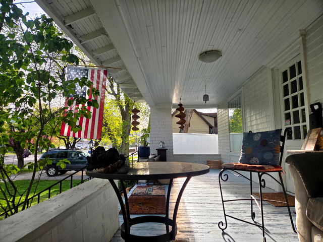 142 West 400 North Logan, UT 84321 - Photo 4 of 35 Expansive covered porch featuring a beadboard ceiling, painted wood flooring, and a windowed entryway