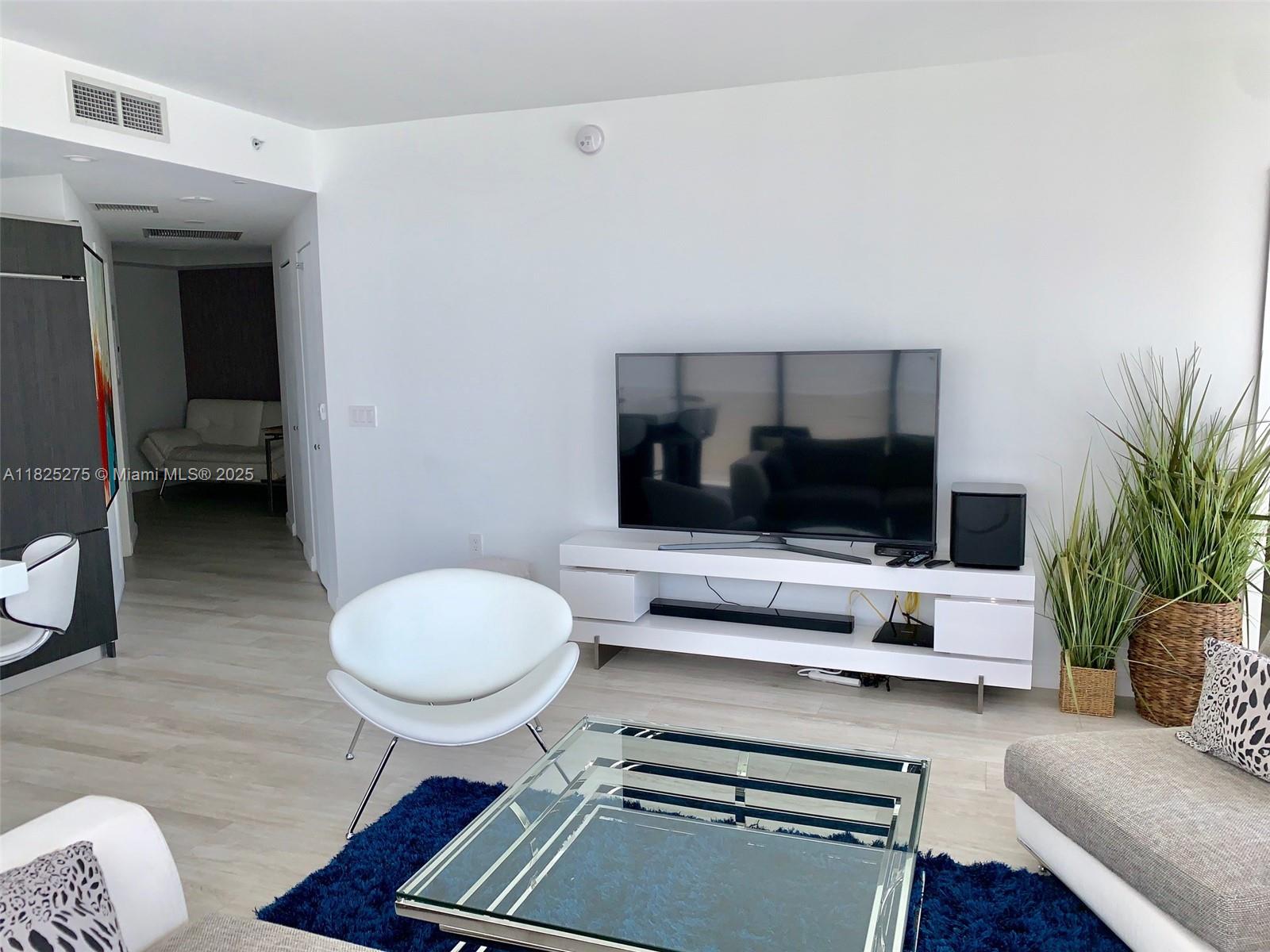 55 Southwest 9th Street, Unit 2706 Miami, FL 33130 - Photo 3 of 8 a living room with furniture and a flat screen tv