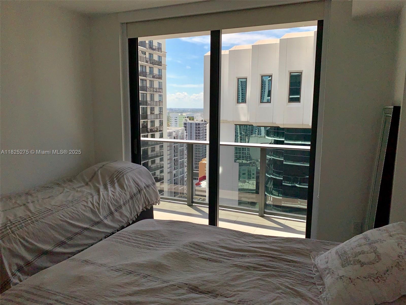 55 Southwest 9th Street, Unit 2706 Miami, FL 33130 - Photo 8 of 8 a bedroom with a bed and a large window