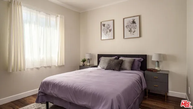 a bedroom with a large bed and a potted plant