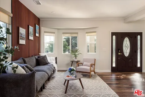 a kitchen with stainless steel appliances a sink a stove a refrigerator cabinets and a dining table