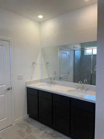a bathroom with a double vanity sink and mirror