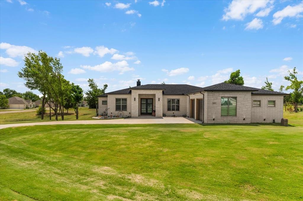 1039 Monaco Court Springtown, TX 76082 - Photo 4 of 33 Contemporary ranch-style residence featuring a light-colored brick exterior and a dark shingle roof