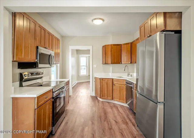a kitchen with stainless steel appliances granite countertop a refrigerator a stove top oven a sink and dishwasher