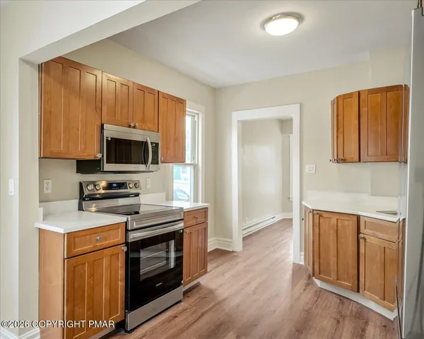 a kitchen with stainless steel appliances granite countertop a stove top oven microwave and cabinets