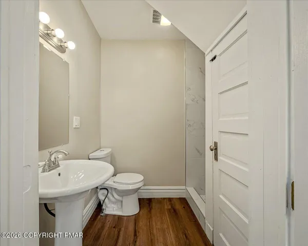 a bathroom with a sink a toilet and shower