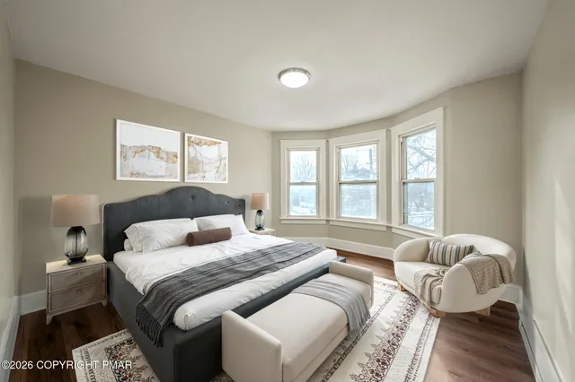 a bedroom with a bed and a large window