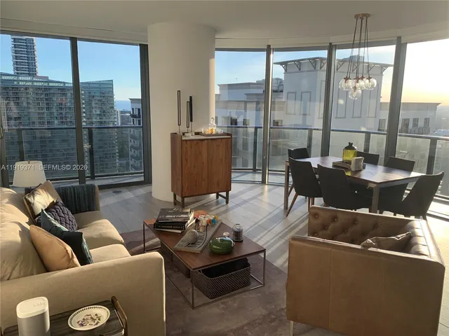 a living room with furniture and a floor to ceiling window