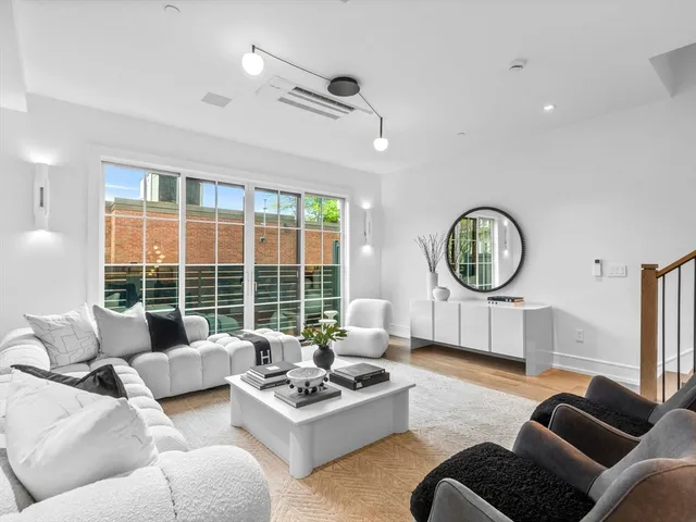 a living room with furniture a large window and a chandelier