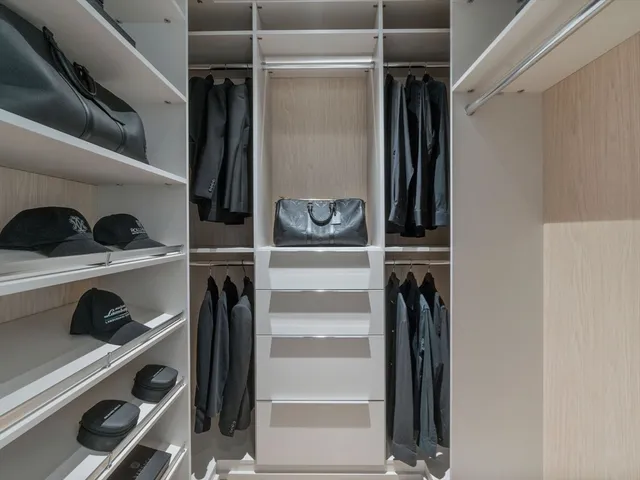 a view of walk in closet with clothes and shoes