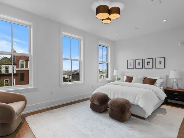 a bedroom with a bed and painting on the wall