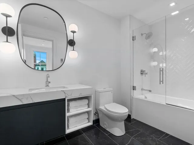 a bathroom with a sink a toilet and shower