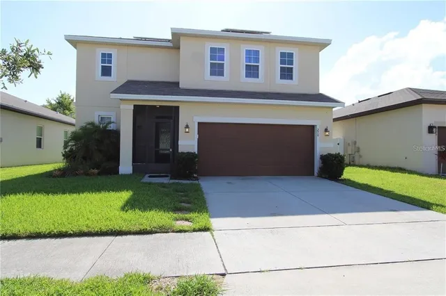 a front view of a house with a yard and garage