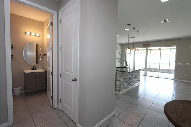 a view of a hallway with furniture and a chandelier