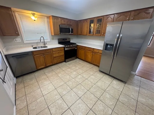 a kitchen with stainless steel appliances a refrigerator sink and microwave