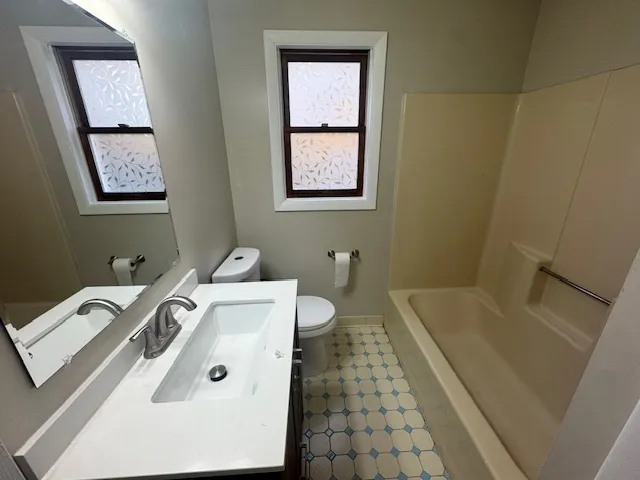 a bathroom with a tub sink and mirror