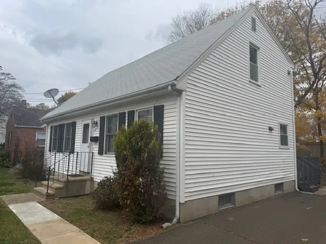 a view of a white house next to a yard